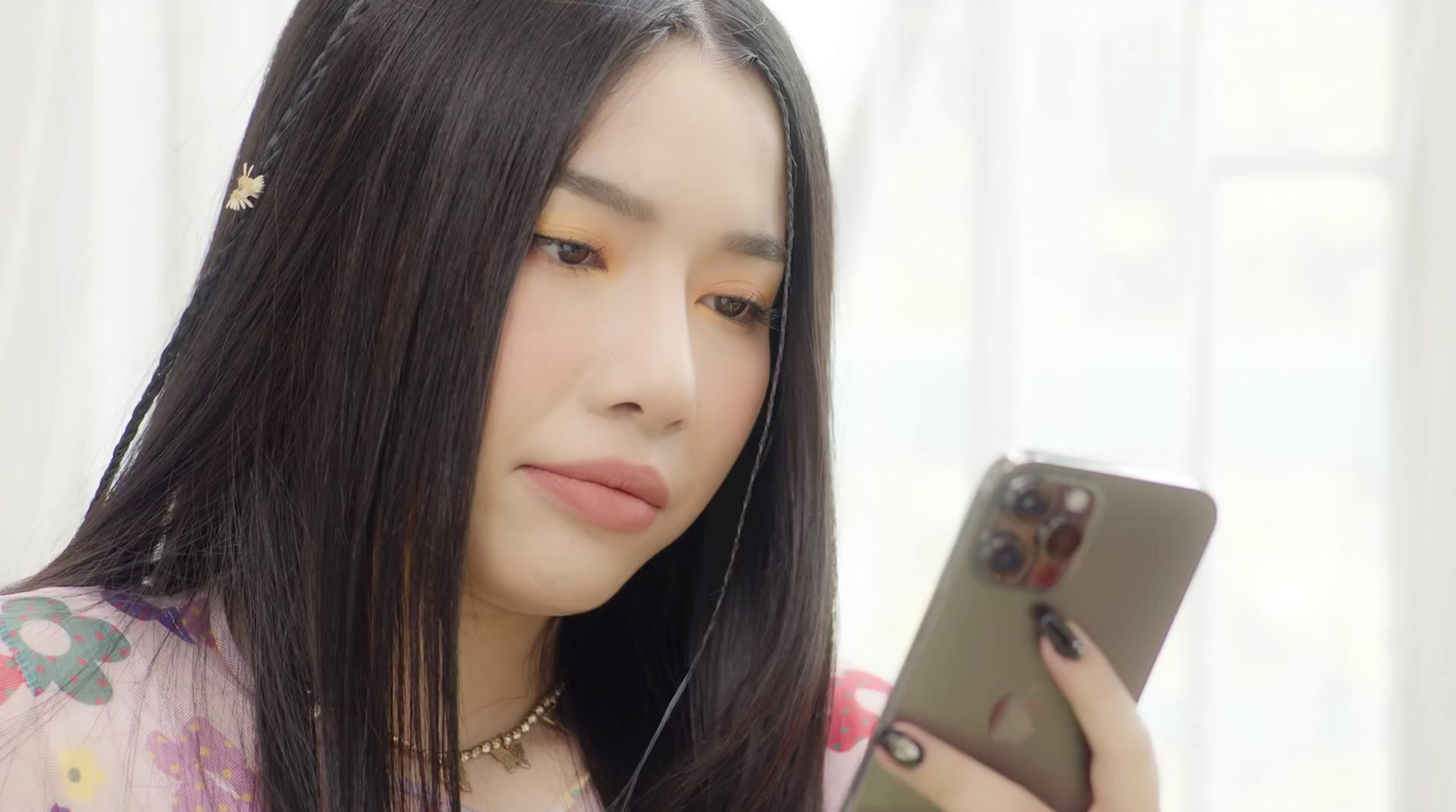 a woman with long black hair holding a cell phone