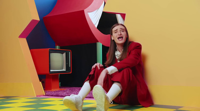 a woman sitting on the floor in front of a tv