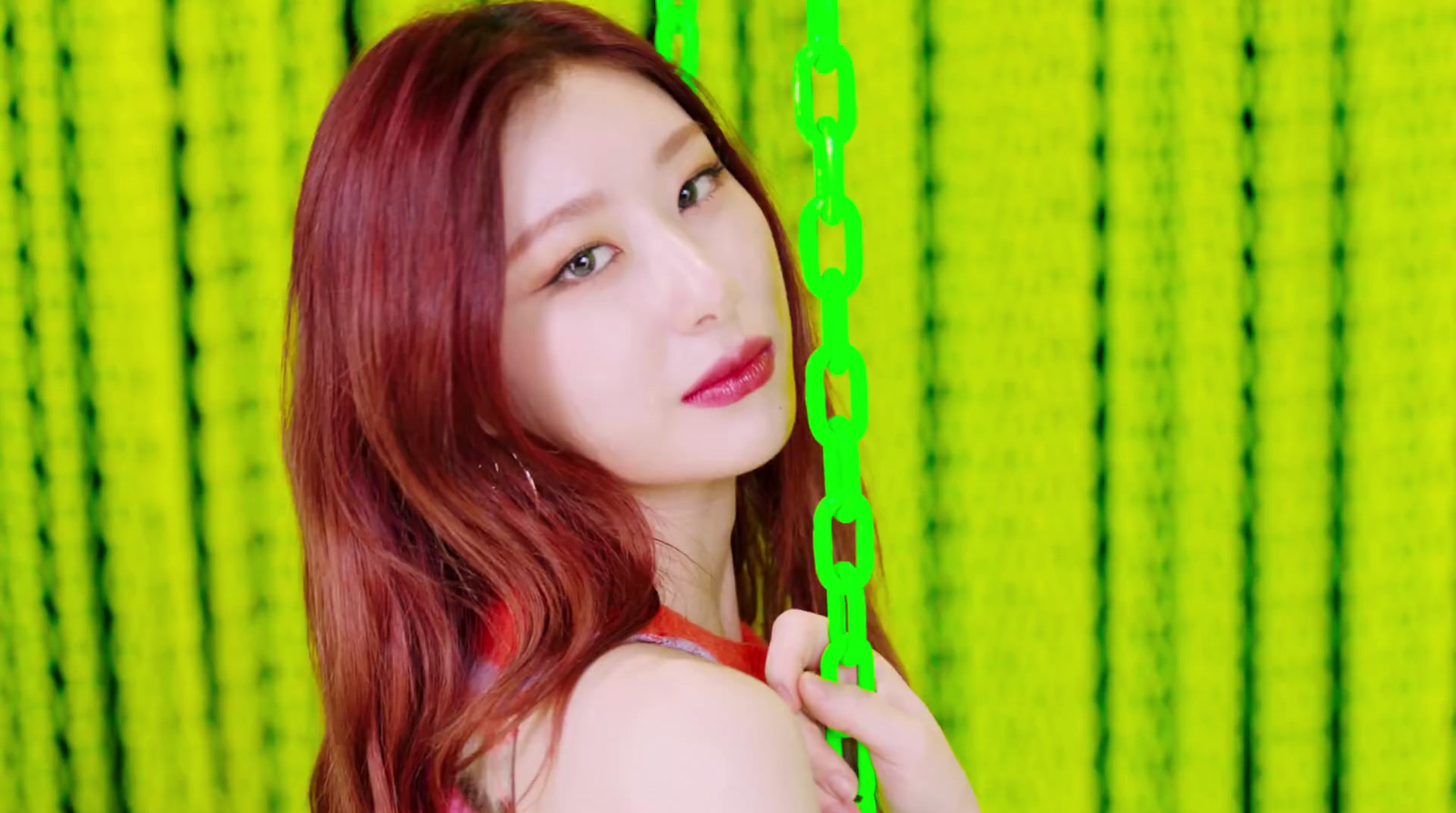 a woman with red hair is holding a green chain