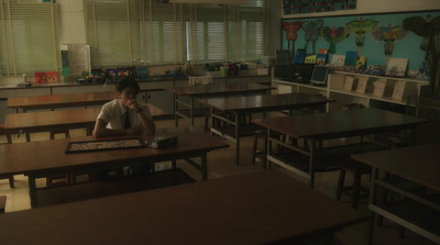 a person sitting at a desk in a classroom