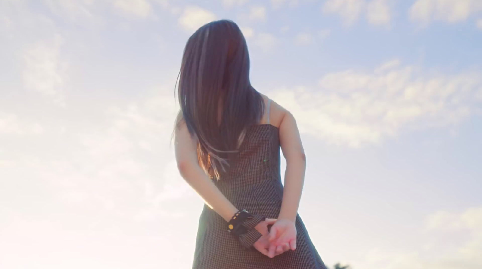 a woman in a dress is holding a skateboard