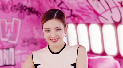 a woman in a black and white dress standing in front of a pink wall