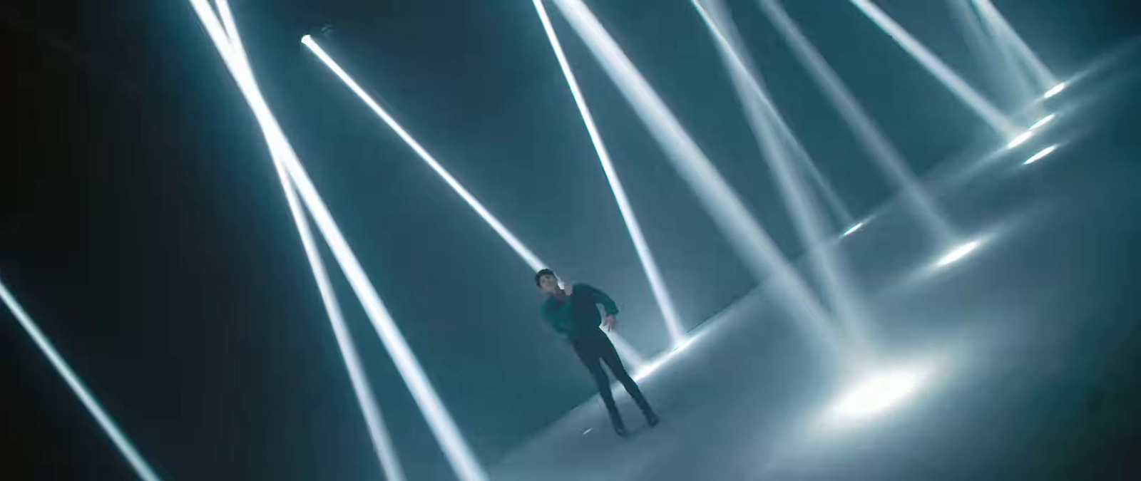 a man standing in the middle of a room filled with lights