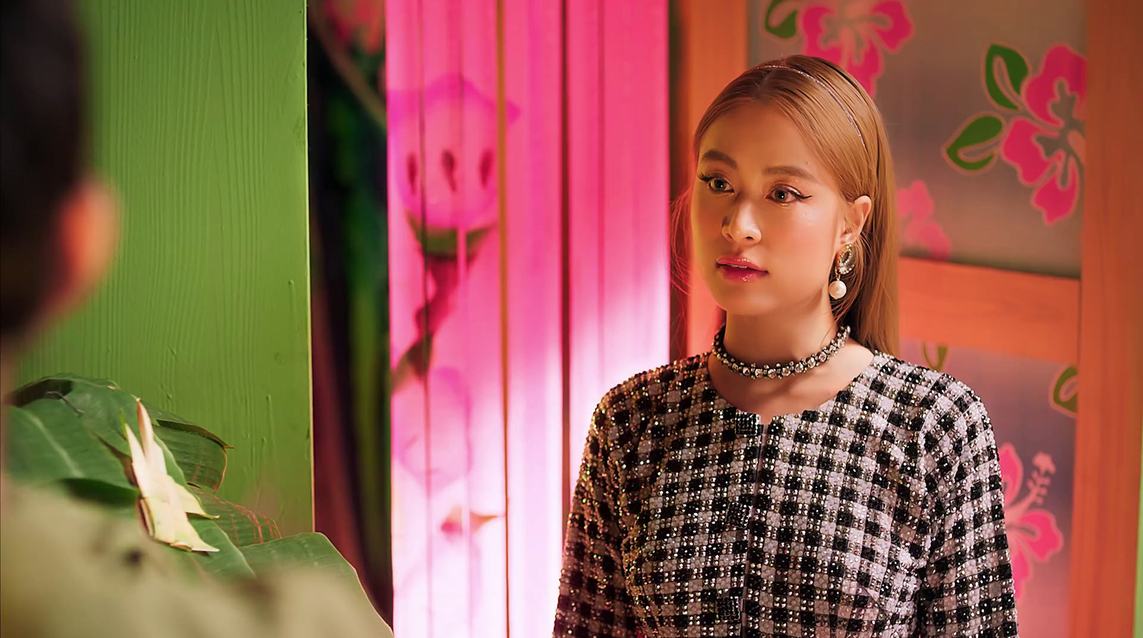 a woman standing in front of a green wall