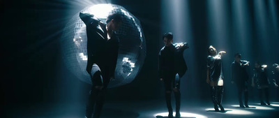 a group of people standing in front of a disco ball