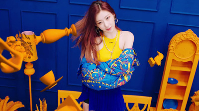 a young woman is posing in front of a blue and yellow wall