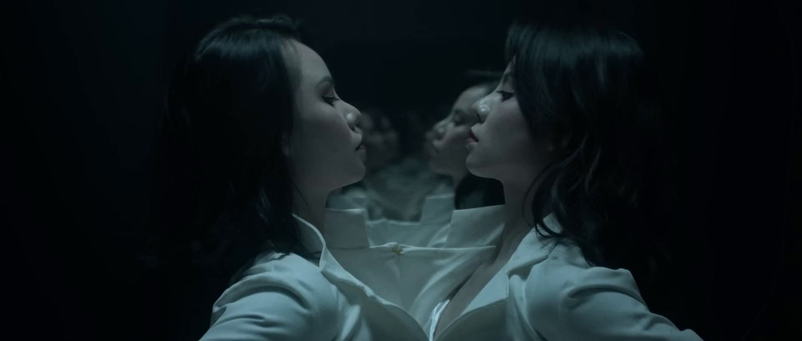 two women standing in a dark room looking at each other