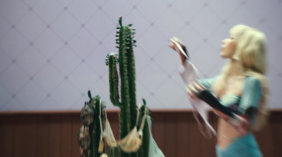 a woman standing next to a tall cactus