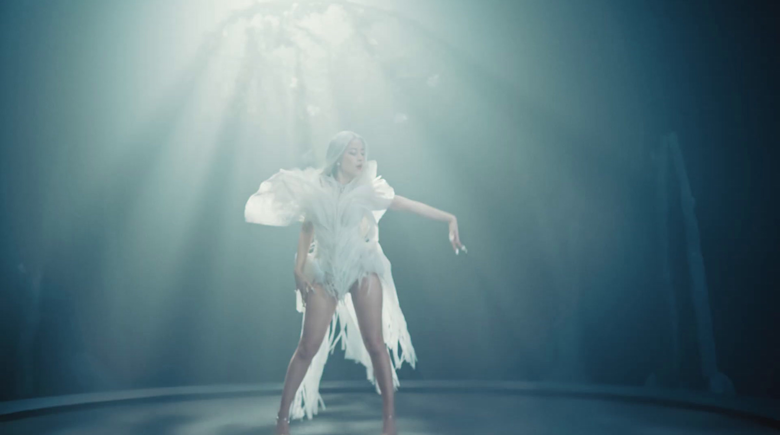 a woman in a white dress dancing on stage