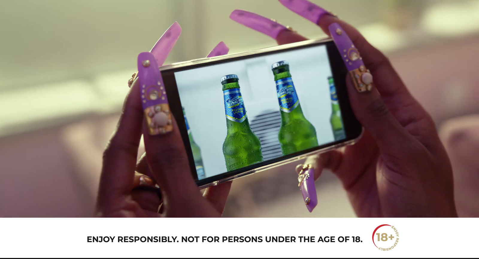 a woman taking a picture of two bottles of beer