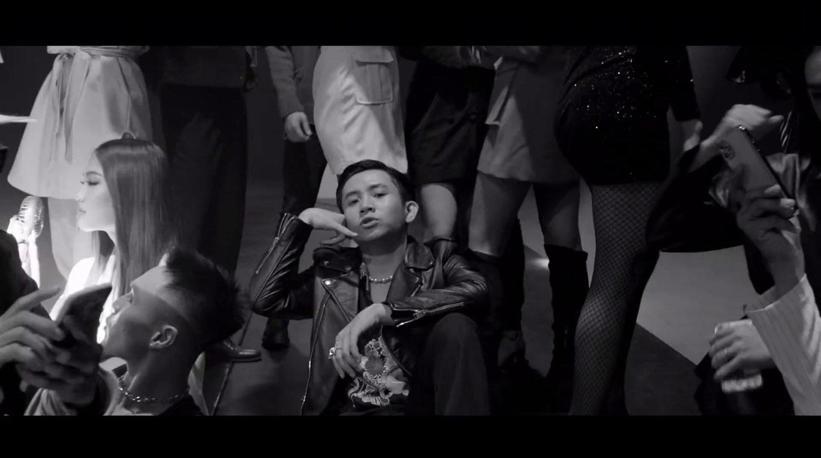 a young boy sitting in front of a crowd of people