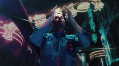 a man standing in front of a neon sign