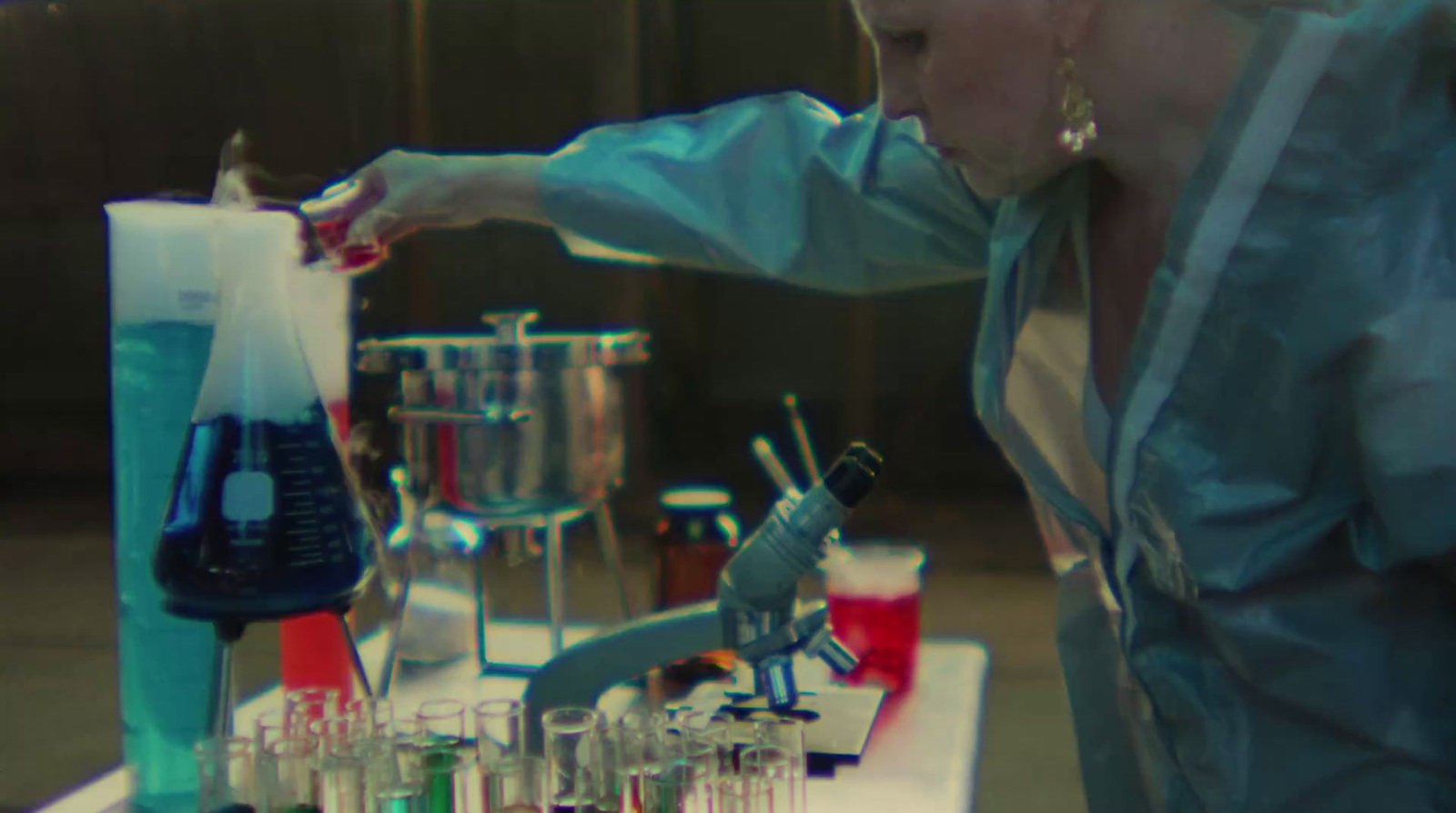 a woman standing in front of a table filled with laboratory equipment