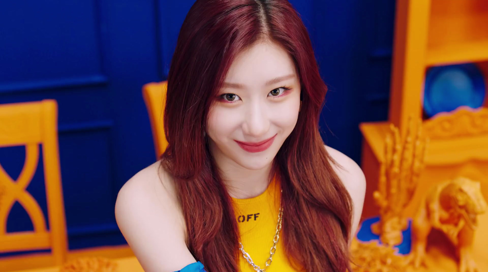 a woman with long red hair sitting in front of a table