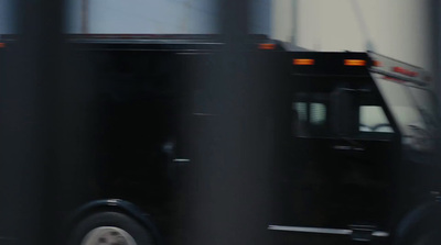 a black truck driving down a street next to tall buildings