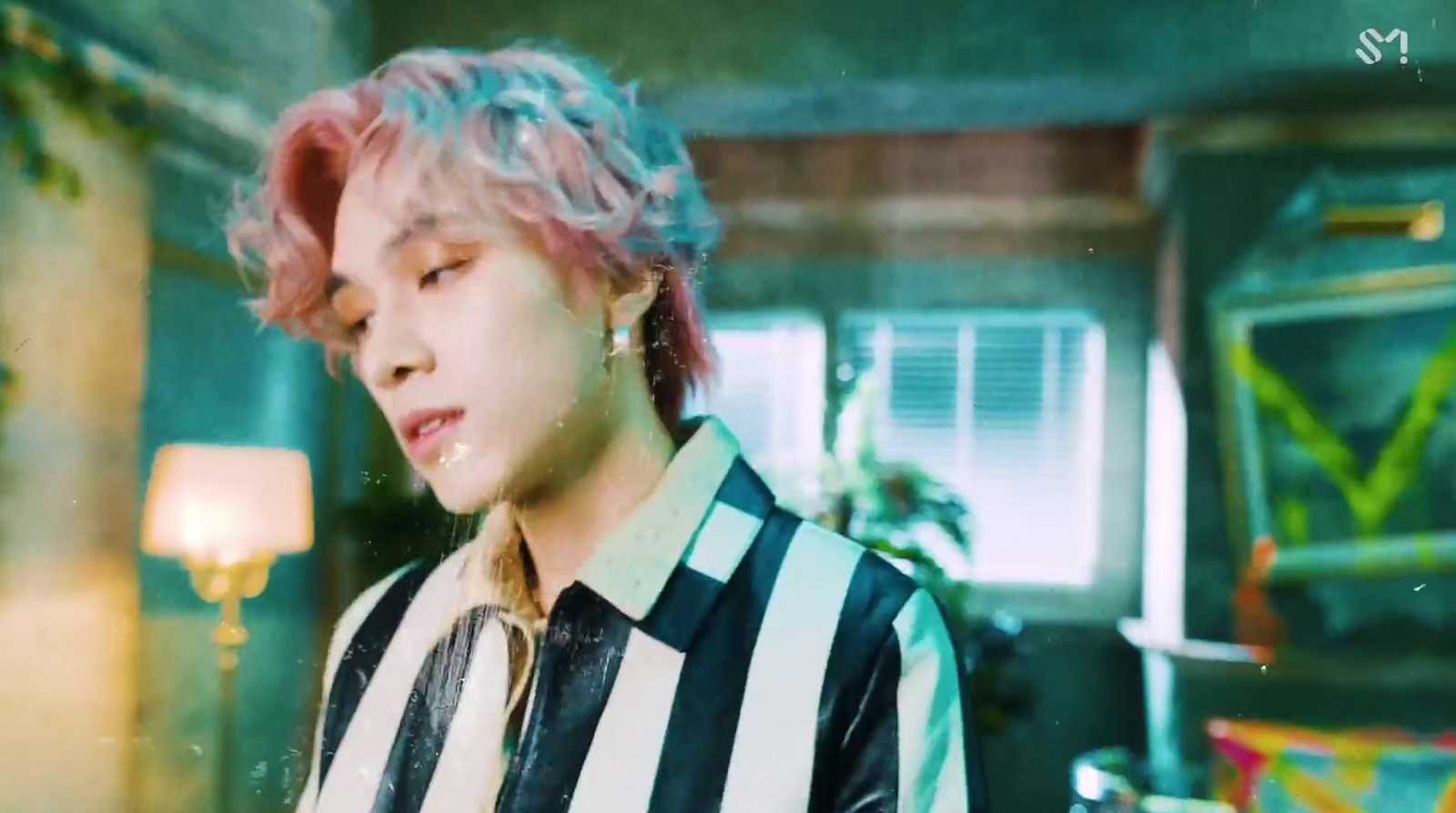 a person with pink hair and a black and white shirt