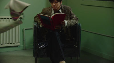 a man sitting in a chair reading a book