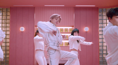 a group of people in white outfits dancing in a room