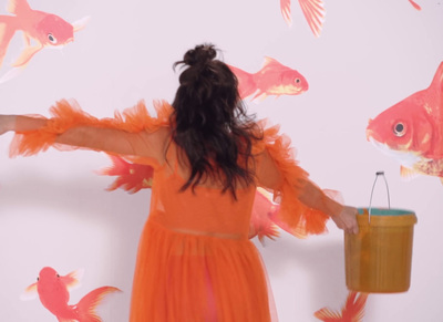 a woman in an orange dress holding a bucket