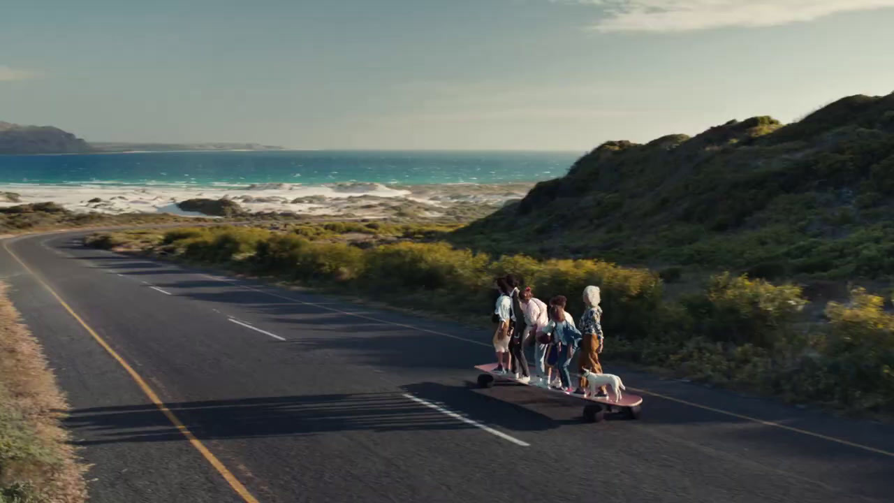 a group of people riding a skateboard down a road