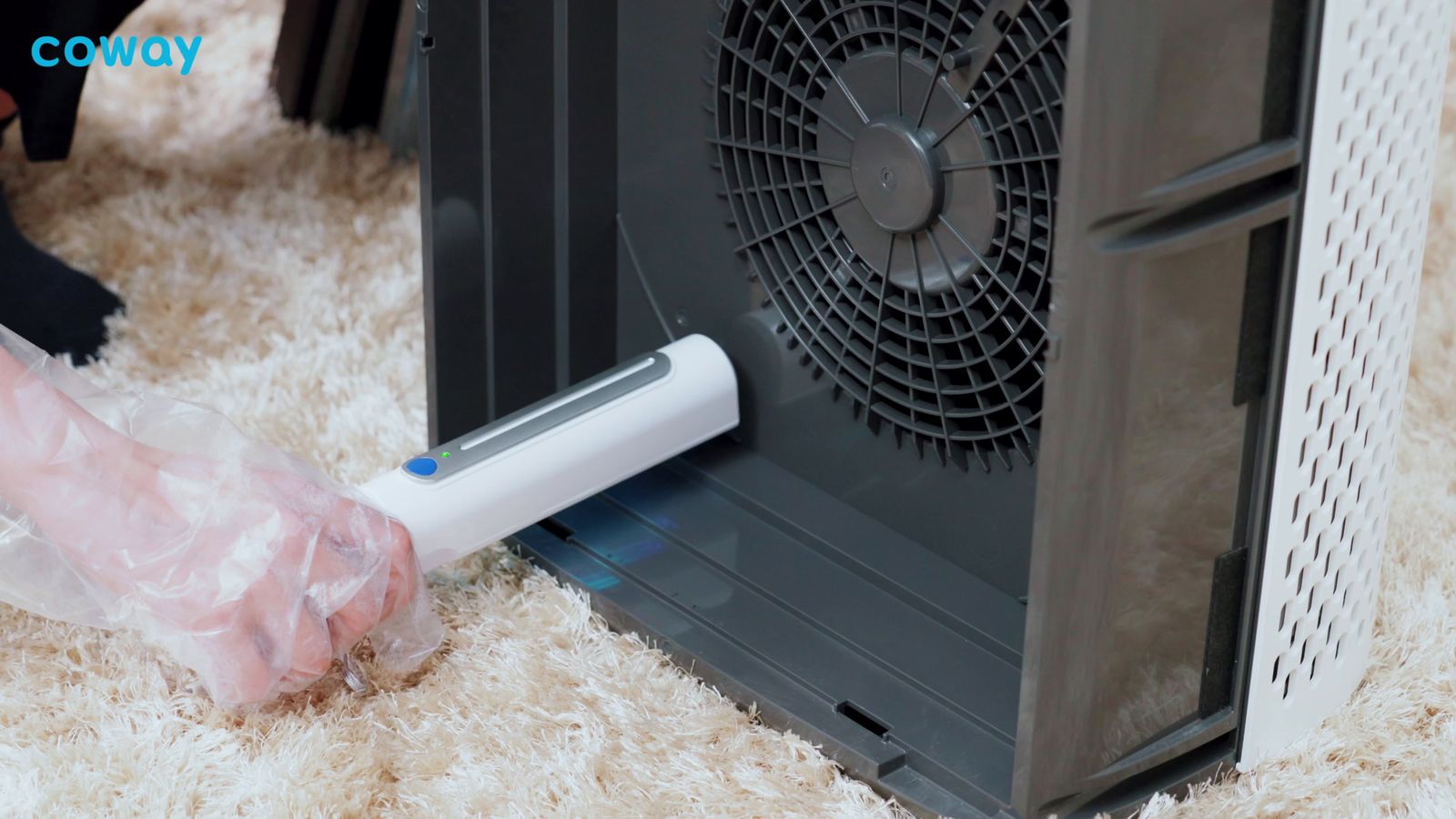 a person cleaning a computer with a vacuum