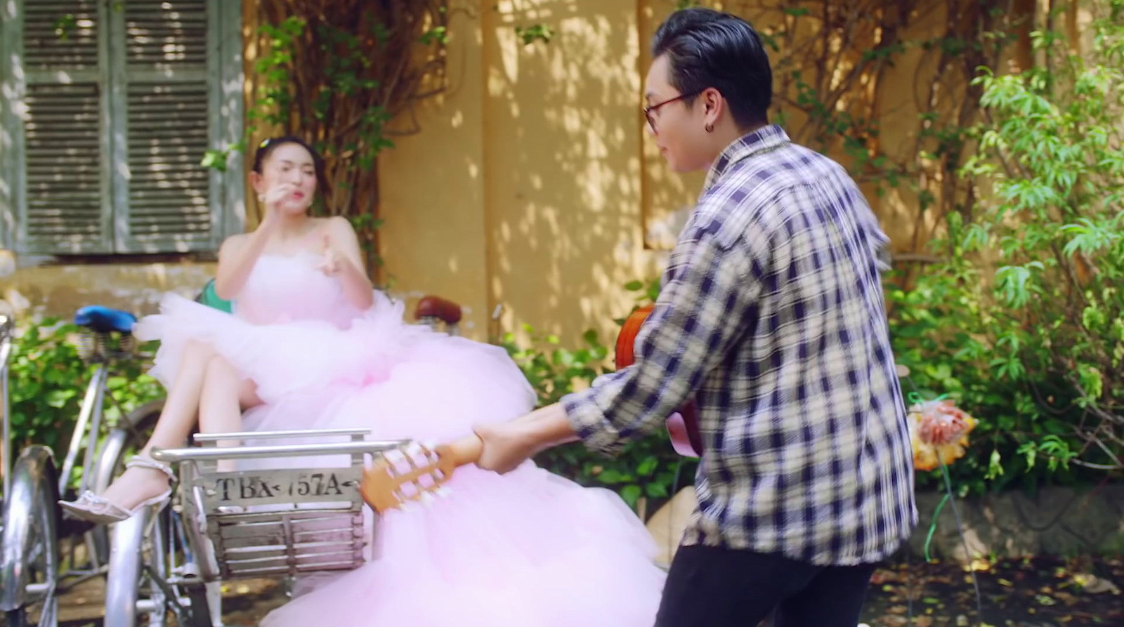 a man pushing a cart with a woman in a pink dress