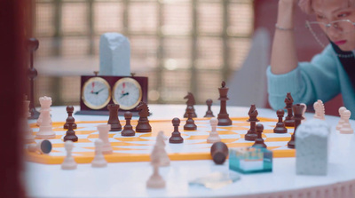 a woman sitting at a table with a chess set