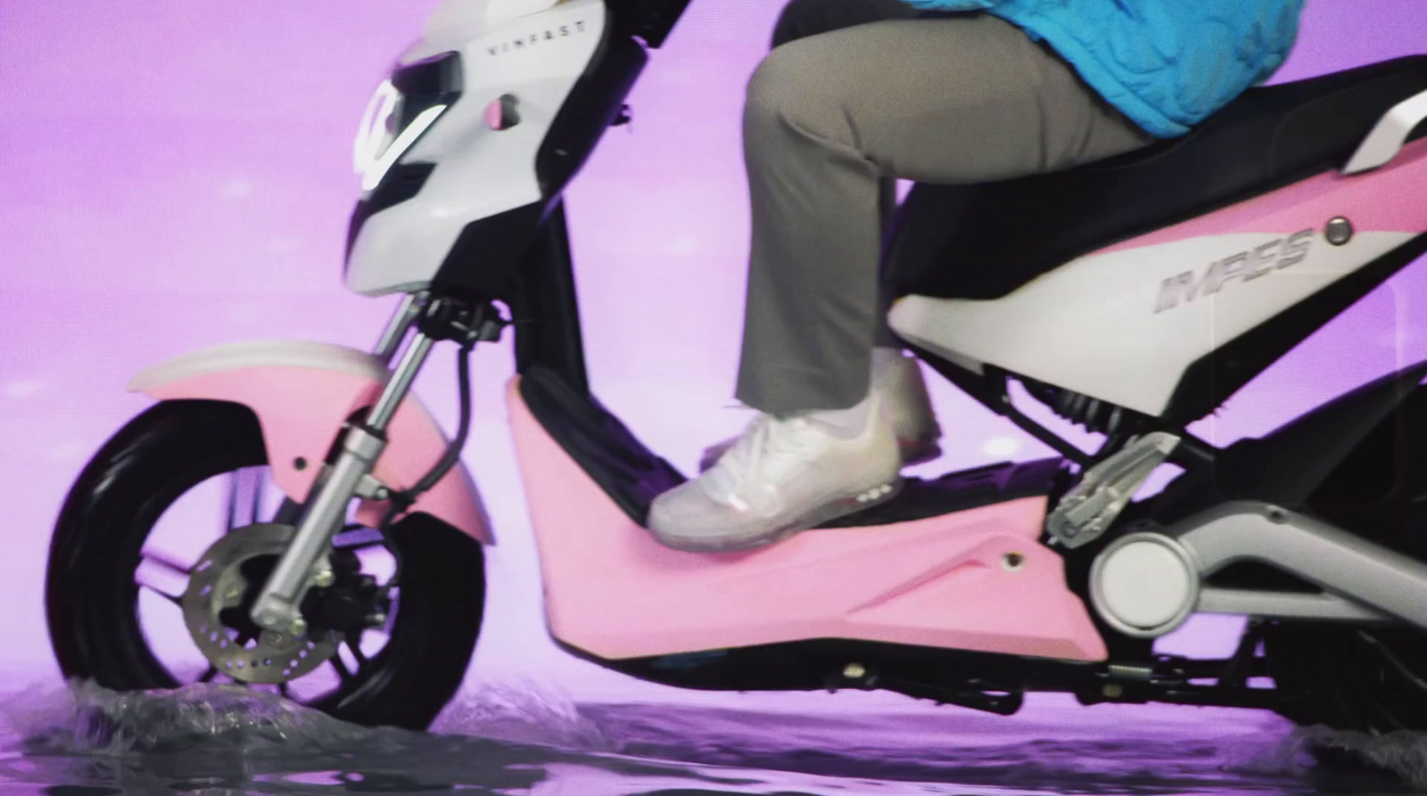 a person riding a pink scooter in the water