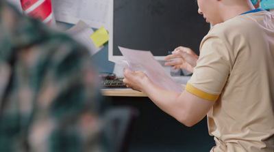 a man sitting at a desk holding a piece of paper