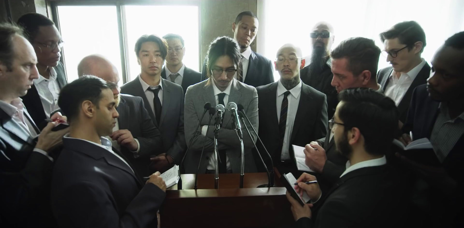 a group of men standing around a microphone