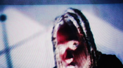 a man with dreadlocks on a television screen