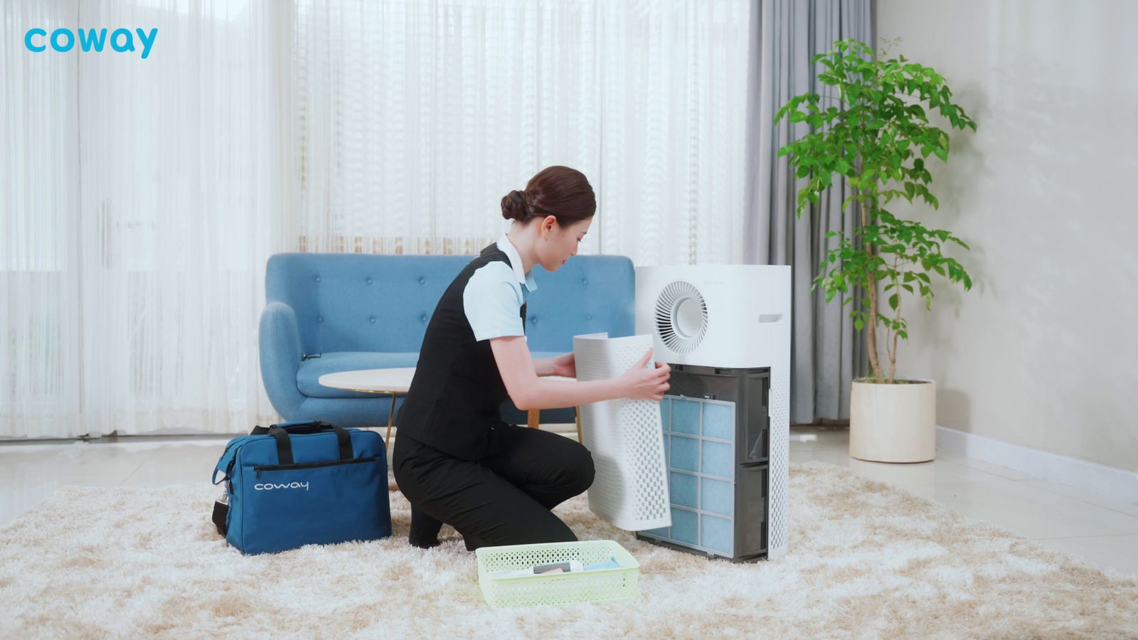 a woman kneeling down next to a small air conditioner