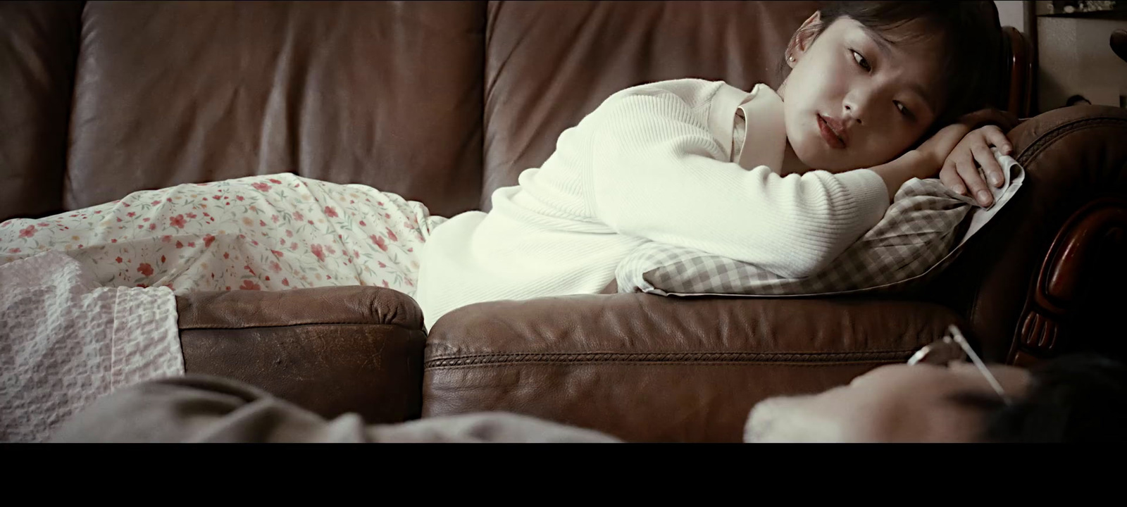 a woman laying on a couch with her arms crossed