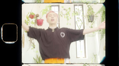 a man standing in front of a wall with potted plants