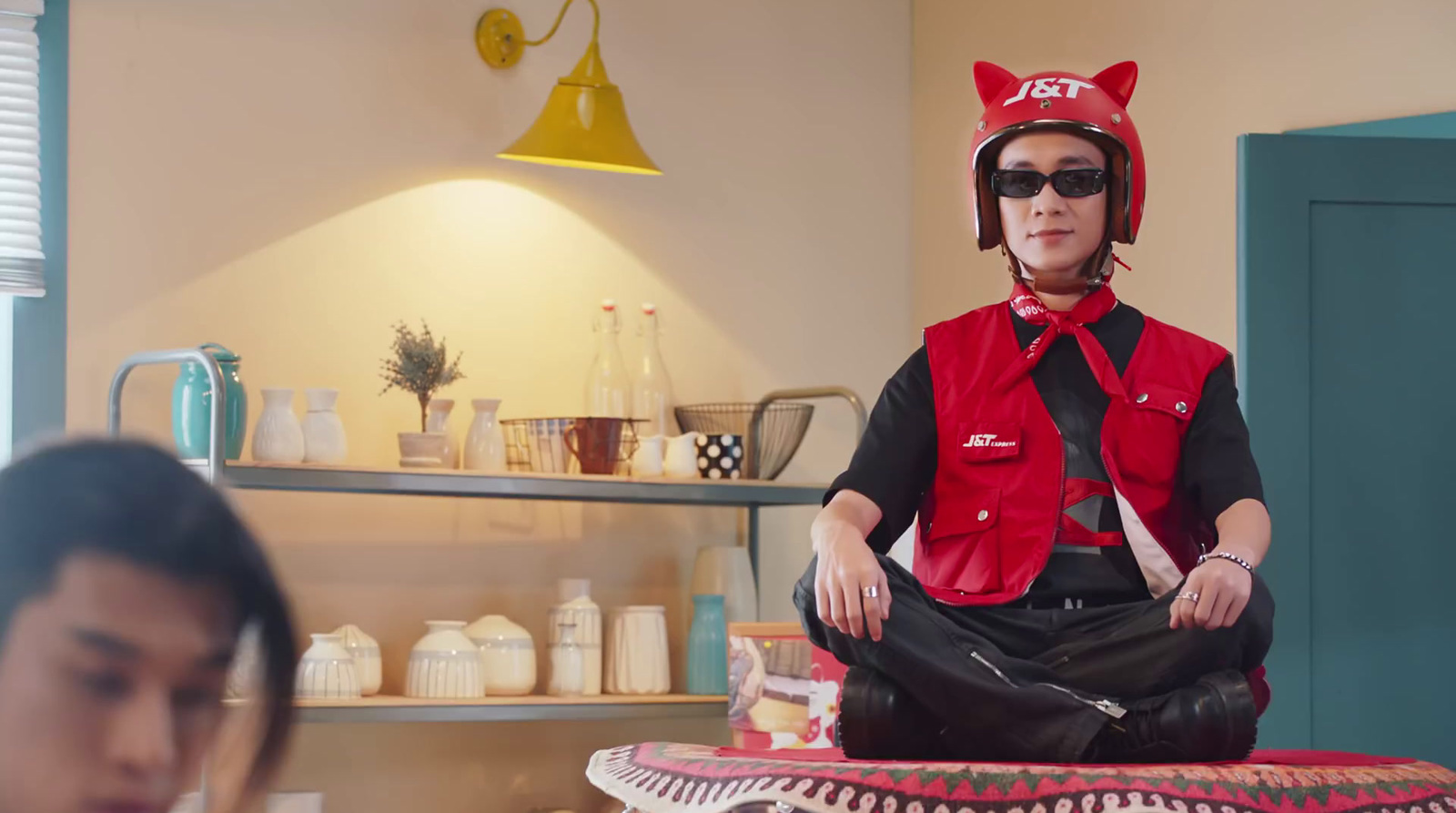 a woman sitting on a stool with a cat hat on