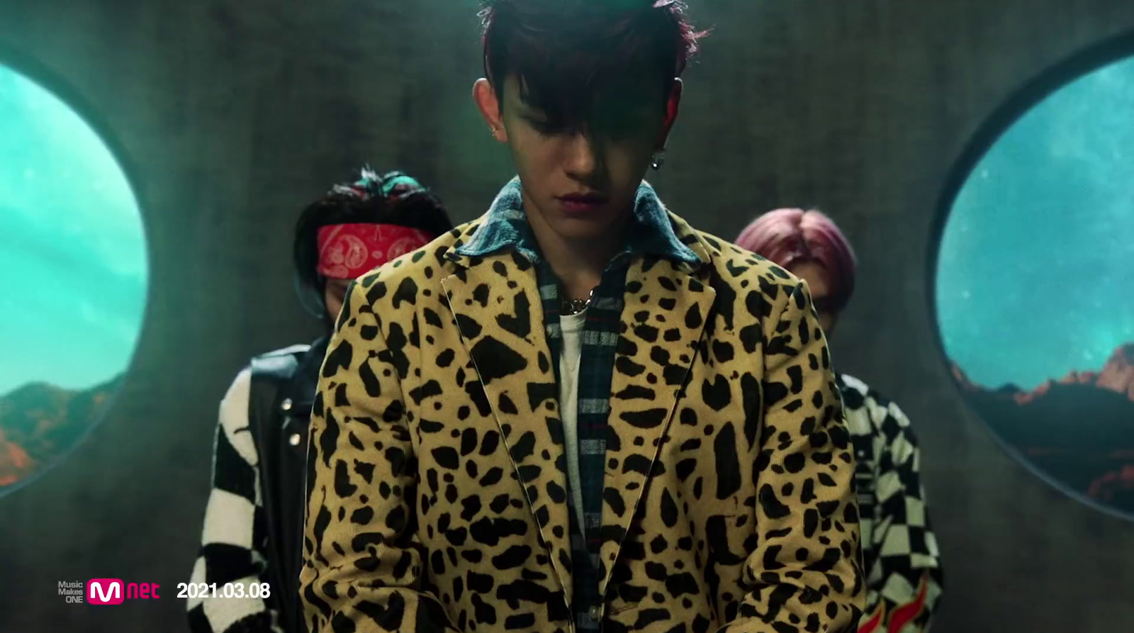 a man in a leopard print jacket standing in front of a group of people