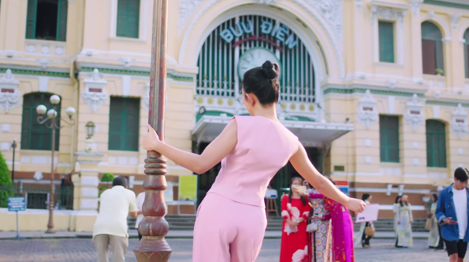 a woman in a pink jumpsuit holding an umbrella