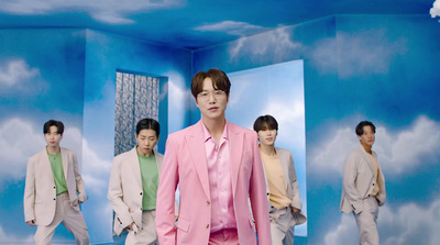 a man in a pink suit standing in front of a group of men