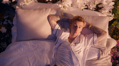 a man laying on a bed covered in white sheets