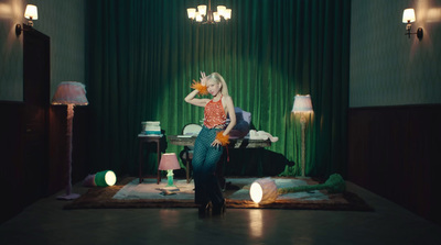 a woman standing in front of a green curtain