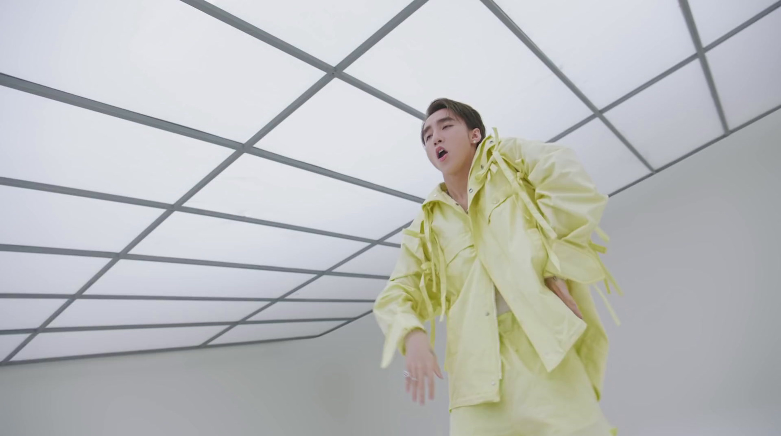 a man in a yellow shirt is standing in a room