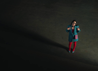 a woman standing in the dark holding a cell phone