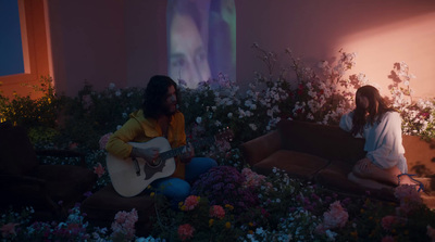 a couple of women sitting on top of a bed of flowers