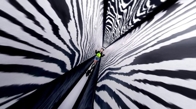 a man standing in the center of a black and white vortex