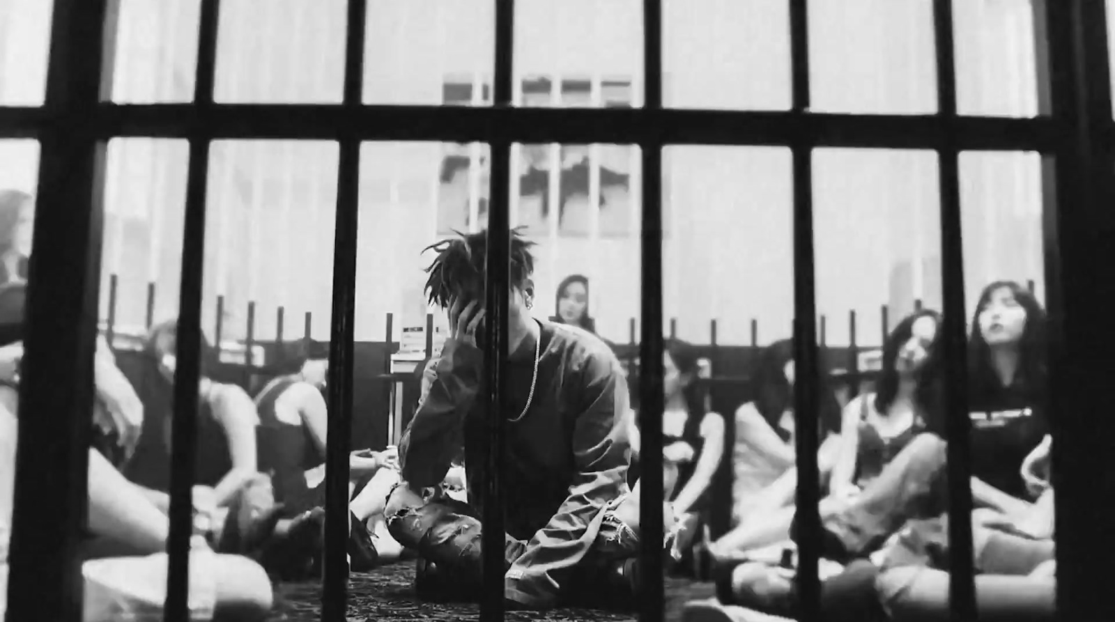 a group of people sitting in a jail cell