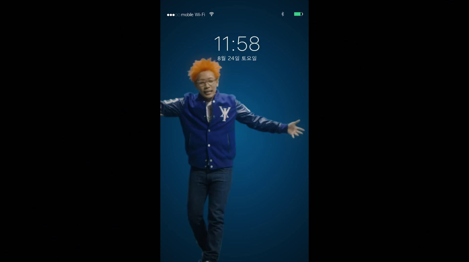 a man with an orange hair standing in front of a cell phone
