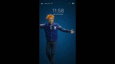 a man with an orange hair standing in front of a cell phone