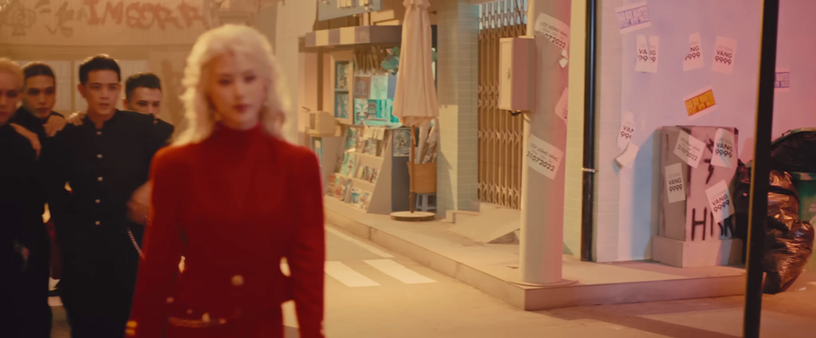 a woman in a red dress walking down a street