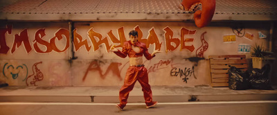 a man standing in front of a graffiti covered wall