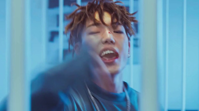 a young man with dreadlocks is screaming in a jail cell